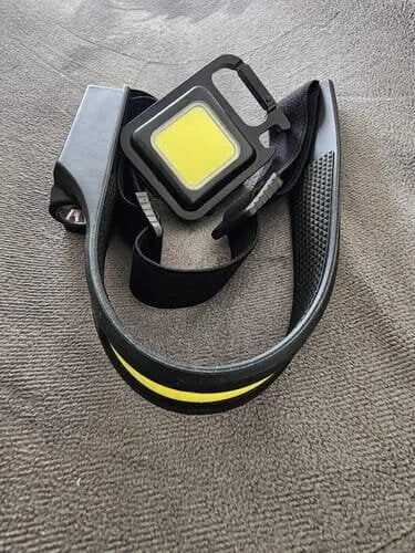 Photo client de la lampe frontale Lumora montrant le bandeau réglable jaune et noir