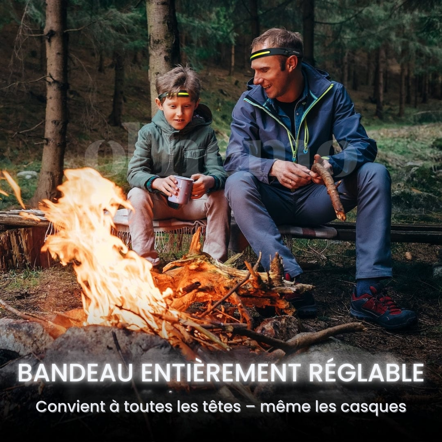 Père et fils autour d'un feu de camp en forêt portant la lampe frontale Lumora à bandeau réglable