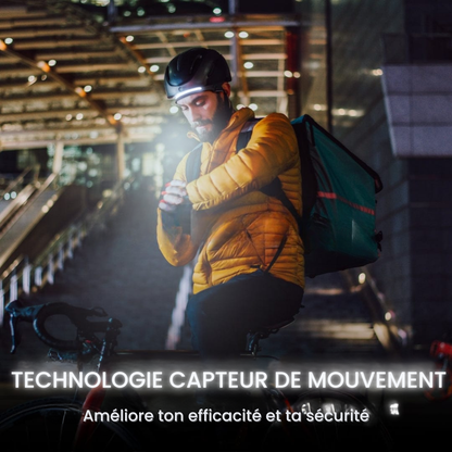 Livreur à vélo en ville la nuit utilisant la lampe frontale Lumora avec capteur de mouvement